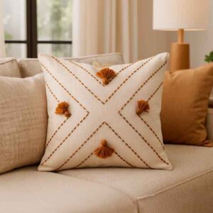 Cojín artesanal beige con bordado café y borlas