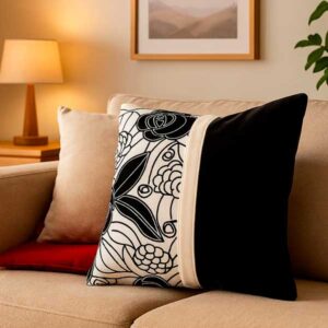Cojín decorativo en terciopelo negro floreado.